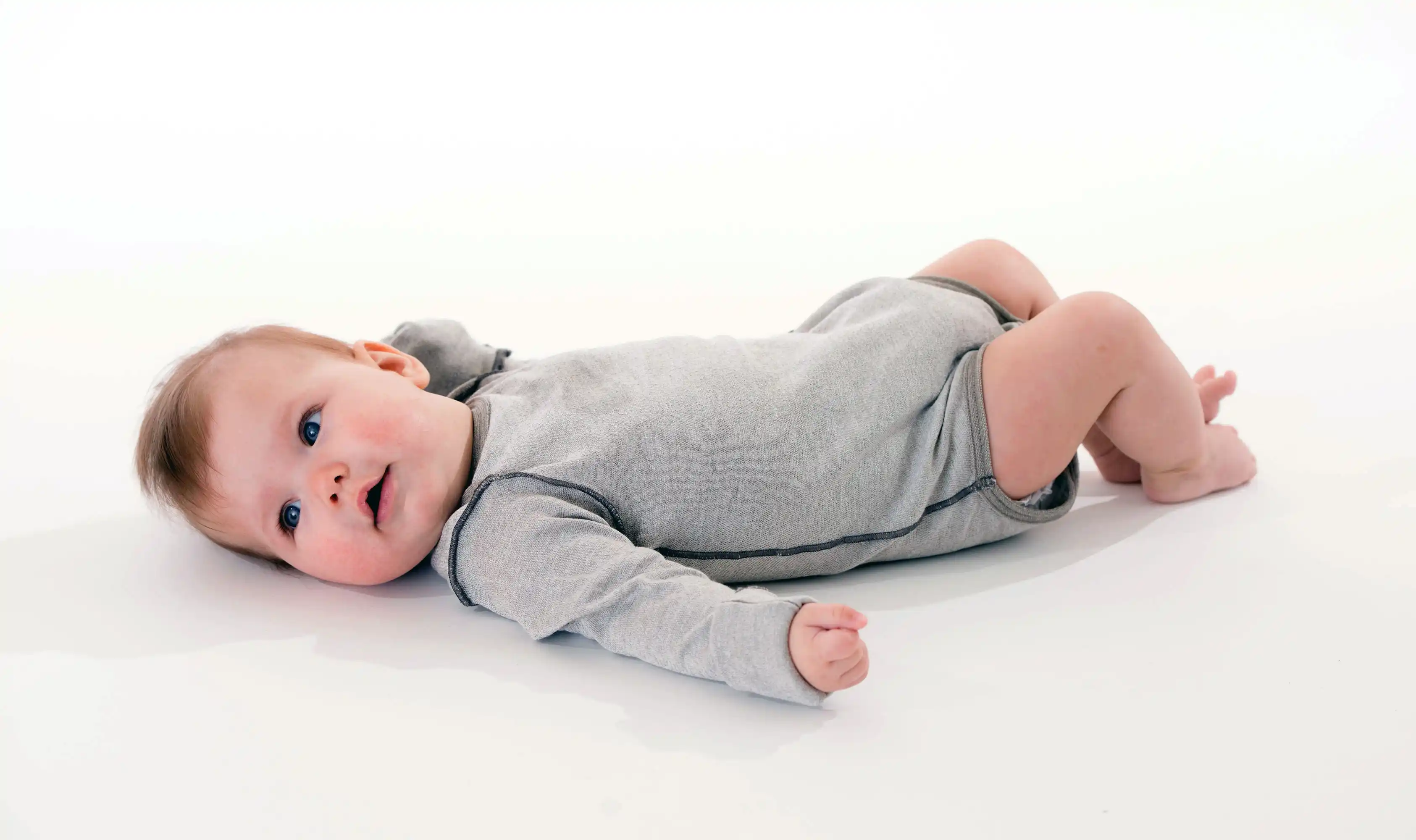 Baby-Langarm-Body silber – getragen von einem Baby, hautfreundliche Silbertextilien, atmungsaktiv und juckreizlindernd.